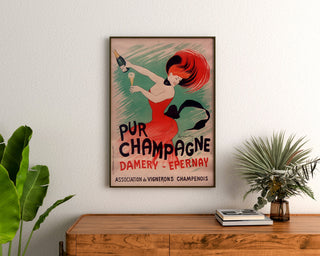 Vintage reclameposter Champagne Damery-Épernay, ingelijst boven een houten dressoir, tussen planten.