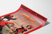 Vintage reclameposter Grandes Galeries modernes, Agen, gepresenteerd op een gebogen vel, schuin gefotografeerd.
