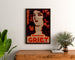 Vintage advertising poster Perfumes Griet, framed above a wooden dresser between plants.