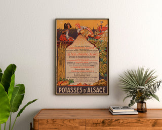 Vintage reclameposter Potasses d’Alsace, ingekaderd boven een houten dressoir, tussen planten.
