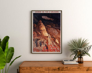 Vintage toeristenposter – Grottes de Lacave, Rocamadour, ingelijst boven een houten ladekast, tussen planten.