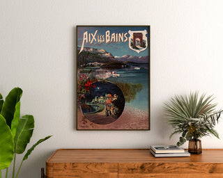 Vintage poster Aix-les-Bains, nachtfeest, ingelijst boven een houten dressoir tussen kamerplanten.