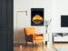 Vintage poster Automoto, Saint-Étienne, ingelijst in een woonkamer met een oranje fauteuil en een vloerlamp.