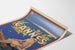 Vintageposter Cannes, Les Sports Élégants, gepresenteerd op een licht gekromde pagina in perspectief.