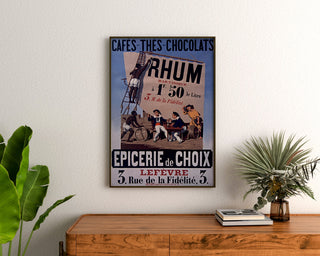 Vintage poster Épicerie Lefèvre, koffie en chocolade, ingelijst boven een houten dressoir, tussen planten.