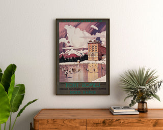 Vintageposter Font-Romeu, wintersport, ingelijst boven een houten ladekast tussen planten.