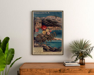 Vintage affiche La Turbie, spoorwegen PLM, ingelijst boven een houten dressoir, tussen planten.