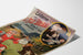 Vintageposter Laiterie de l’Isle Briant, Angers, gepresenteerd op een gekromde pagina, perspectivisch zicht.