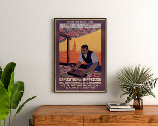 Vintage poster Mulhouse, lithografische expositie, ingekaderd boven een houten dressoir, tussen planten.