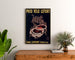 Vintage poster Fietsbanden Lefort, ingelijst boven een houten ladekast, tussen planten.
