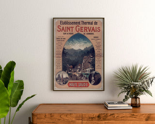Vintageposter Saint-Gervais, kuuroord, ingelijst boven een houten dressoir tussen planten.