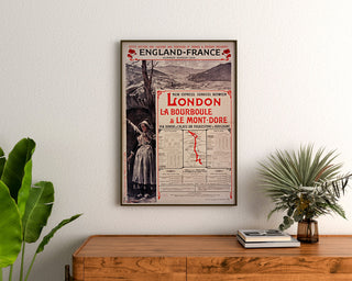 Vintage poster South Eastern, England-France, ingelijst boven een houten dressoir, tussen planten.