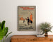 Vintageposter Two Little Vagabonds, ingelijst boven een houten dressoir, tussen planten.