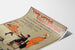 Vintageposter Two Little Vagabonds, gepresenteerd op een gebogen vel papier, perspectiefaanzicht.