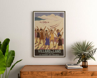 Vintage poster Villard-de-Lans, SNCF, ingelijst boven een houten ladekast, tussen planten.